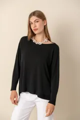 Sweater negro de tejido de punto, con escote barco y mangas largas.