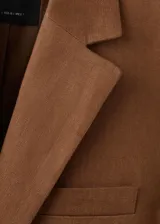 Blazer de lino color marrón, de diseño recto, con cuello pico con solapa, manga larga y cierre de un botón en la parte delantera.