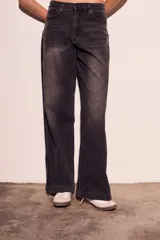 Pantalón de jean negro con efecto desgastado, corte wide leg y cierre con cremallera en los tobillos.