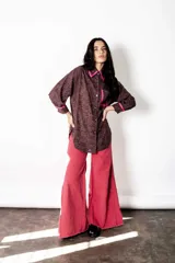 Camisa de broderie color chocolate con detalles de bies en color fucsia en el cuello, bolsillos y puños. Presenta un corte amplio, estilo relajado, mangas largas y cierre frontal con botones.