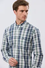 Camisa de manga larga de calce slim, con diseño a cuadros en tonos azul oscuro, verde y blanco. Presenta cuello camisero con botones y bolsillo ojal en el pecho con detalle bordado.