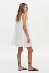 Vestido corto de lino blanco, sin mangas, con cuello redondo y diseño holgado.