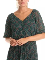 Vestido midi de gasa estampada en tonos verdes y marrones, con escote en V cruzado en la parte delantera y escote redondo elastizado en la espalda. Presenta cintura elastizada con lazo fino para anudar, mangas cortas evasé con volumen y falda con volados escalonados. Incluye forro interno a tono.