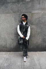 Mono de jean con lavado gris efecto desgastado, con múltiples cortes estructurales, cierre frontal oculto por cartera, cintura elástica y bordado de logo en azul. Incluye un pequeño accesorio de bolso desmontable para la cintura.