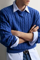 Sweater de punto verde con diseño de trenzas, cuello redondo y manga larga, de corte regular fit y acabados en rib.