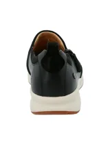 Zapatilla tipo slip-on Hush Puppies modelo Spinal, confeccionada en cuero negro con detalles en gamuza y cierre lateral. Cuenta con una suela de goma blanca con base antideslizante y tecnología de amortiguación.
