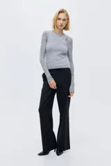 Pantalón de vestir con corte bootcut, confeccionado en tela negra con diseño de rayas finas verticales. Presenta cierre frontal con pretina prolongada, bolsillos laterales al bies y bolsillos traseros ribeteados, con detalle de raya marcada en el frente y la espalda.