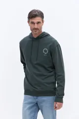 Canguro con capucha de algodón en color verde oscuro. Presenta un diseño de manga larga con puños y ruedo acanalados, capucha con cordones ajustables y un pequeño estampado circular con el logo de la marca en el pecho.