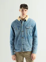 Campera de jean celeste con cuello de corderito color crema, cierre con botones metálicos, bolsillos frontales con solapa y puños abotonados.