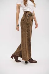 Pantalón de jean de corte wide leg con efecto de lavado ácido en tono marrón. Presenta tiro alto, cierre frontal con botón y bolsillos laterales.