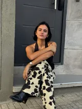 Pantalón de tiro alto color beige con estampado de manchas de vaca en marrón oscuro.