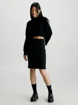 Falda corta negra de tejido acanalado, corte slim y cintura elástica. Presenta una cinta con logo en el lateral izquierdo en tonos verde y negro.