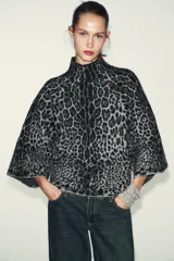 Jersey de punto con estampado animal jacquard en tonos gris y negro, caracterizado por su cuello subido y mangas anchas de corte holgado.