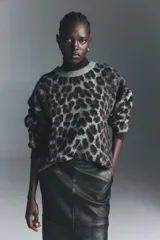 Buzo oversized de punto jacquard con estampado de leopardo, cuello redondo acanalado y hombros caídos. Presenta puños y bajo con terminación acanalada.