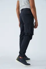 Pantalón cargo de corte slim, color verde militar, con cierre frontal, botón en la cintura, pasacintos y bolsillos laterales con solapa y botones.
