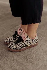 Zapatillas Adidas Samba con estampado animal print en blanco y negro, detalles en cuero beige y suela de goma color caramelo.