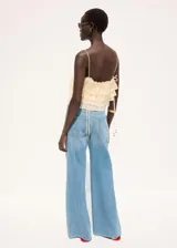 Pantalón de mezclilla de tiro medio con diseño acampanado estilo flare, trabillas para cinturón y clásico diseño de cinco bolsillos con cierre frontal de botón y cremallera.