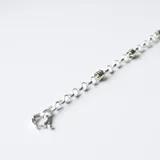 Pulsera de eslabones tipo rolo, confeccionada en plata con detalles intercalados en oro. Presenta un cierre marinero circular.