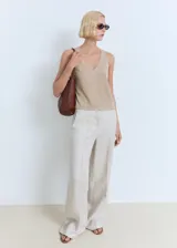 Top sin mangas de tejido de punto fino, con cuello en pico y tirantes anchos. Presenta un diseño recto y minimalista.