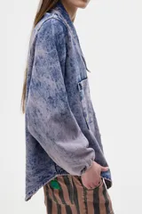 Camisa de jean oversized con lavado washed. Escote en V bajo con cuello camisero, mangas abullonadas.