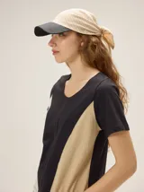 Gorro pañuelo confeccionado en lino, con visera oscura y diseño combinado de rayas finas.