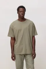 Remera de algodón color verde oliva, con cuello redondo, mangas cortas y corte holgado. Presenta un pequeño bordado en forma de cruz en color amarillo neón en el pecho.