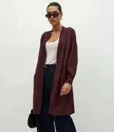 Cardigan alargado de punto color bordó, con diseño abierto, mangas largas y bolsillos frontales. Confeccionado en tejido de punto con viscosa certificada.