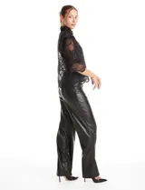 Pantalón de eco cuero negro, de corte wide leg, con costura frontal decorativa, cierre y broche interno en la pretina.