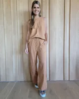 Pantalón de lino color tostado, de corte recto y holgado, con cintura elástica y cordón ajustable.