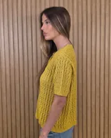 Cardigan calado de manga corta, tejido en punto con cierre frontal de botones y cuello redondo.