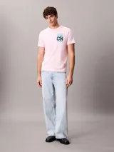 Remera rosada de manga corta con cuello redondo y corte regular, confeccionada en algodón regenerativo. Cuenta con un estampado gráfico en caja de color celeste con el monograma "ck" en negro en el pecho.