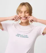 Pijama largo de dos piezas compuesto por una remera rosada de manga corta con cuello redondo y estampa frontal de texto, y un pantalón jogger con cintura elástica y estampado de cuadros vichy en tonos verdes y blancos.