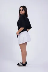 Minifalda negra de tussor con cintura elastizada y volado en el ruedo.