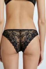 Bombacha tipo vedetina de color blanco, confeccionada en una combinación de tela lisa y detalles de encaje en los laterales. Presenta un pequeño lazo decorativo en el centro de la cintura.