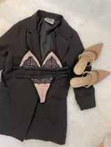 Conjunto de lencería compuesto por un corpiño triangular y una tanga, ambos confeccionados en lycra color beige con detalles de encaje negro y elásticos a tono.