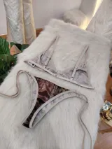 Conjunto de bikini confeccionado en terciopelo con estampado en tonos marrones degradados. El corpiño es de estilo triangular con breteles regulables y cierre frontal con argolla metálica. La bombacha es de corte brasilero, con tiras laterales ajustables para atar.