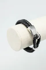 Pulsera de cuero trenzado color negro con cierre metálico plateado.