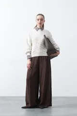 Sweater de punto tramado color azul marino, con cuello redondo, mangas abullonadas y puños elastizados.