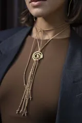 Gargantilla de gamuza marrón con dije de espiral dorado y cuentas de bronce.