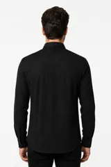 Camisa de viscosa color blanco, de corte holgado, con mangas largas, cuello clásico y cierre frontal de botones.