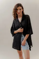 Saco calado negro tejido a máquina, con cuello tipo camisa y mangas 3/4.