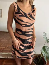 Camisón corto con estampado animal print de cebra en tonos marrones y negros. Presenta cuello redondo con volados y breteles finos.