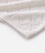 Camisa polo de manga corta con diseño de tejido calado tipo crochet y textura de rombos. Presenta cuello polo clásico y terminaciones en tejido acanalado.