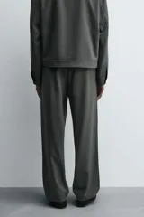 Pantalón regular fit color marrón oscuro, confeccionado en tejido con viscosa. Cuenta con cintura elástica, bolsillos delanteros y detalle de bolsillos traseros de vivo. El cierre frontal es con cremallera y botón.
