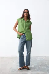 Camisa sin mangas de lino color verde, con cuello clásico, cierre frontal de botones y costura horizontal en el pecho.