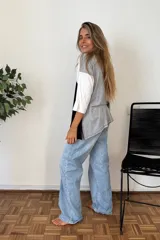 Remerón de manga tres cuartos con diseño de bloques de color en diagonal: gris claro en la parte superior izquierda, negro en la parte inferior derecha y blanco en la manga derecha. Posee cuello redondo y calce holgado.