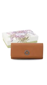 Billetera larga de símil cuero color marrón claro, con solapa frontal decorada con un aro metálico central. Cuenta con múltiples compartimentos internos para tarjetas, billetes y un monedero con cierre.