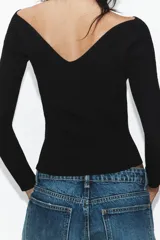 Top de punto acanalado color negro, con escote en pico tanto en el frente como en la espalda y mangas largas.