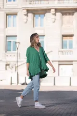 Saco verde esmeralda de tejido morley con botones de madera, corte holgado, escote en V, mangas largas y volados en el ruedo.