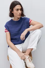 Pantalón jean de tiro alto con calce straight y pierna recta, confeccionado en denim de aspecto limpio. Cuenta con cinco bolsillos, cierre frontal con botón y presillas para cinturón.